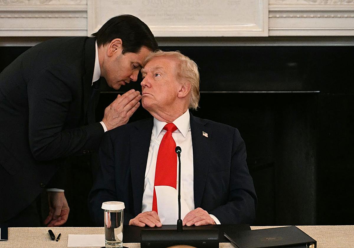 El secretario de Estado de Estados Unidos, Marco Rubio, le susurra al oído al presidente Donald Trump durante una mesa redonda sobre antifa