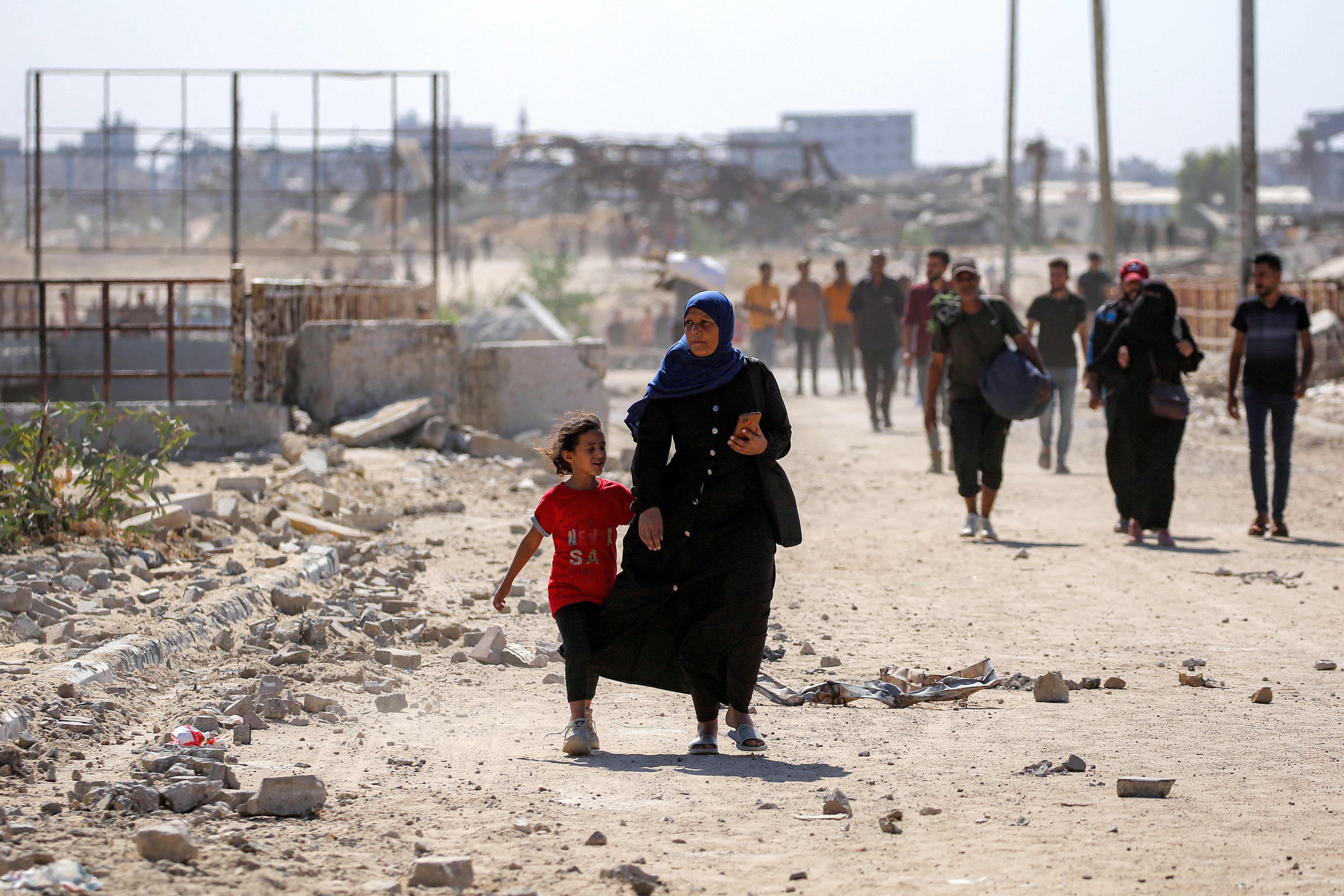 Una mujer con su hija regresando a Ciudad de Gaza.