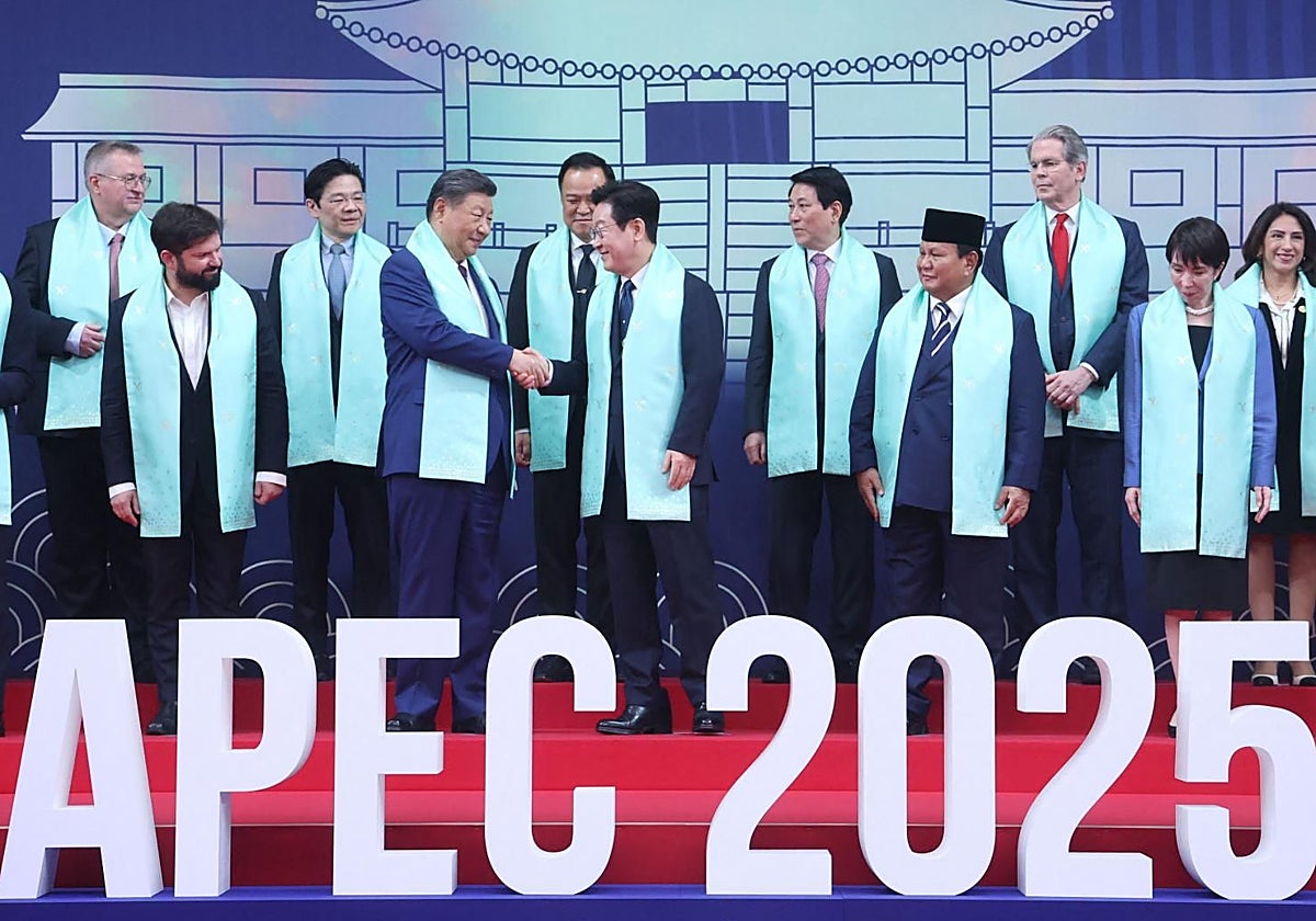 Xi Jinping estrecha la mano del presidente surcoreano, Lee Jae-myung, ante el resto de dirigentes presentes en la cumbre APEC