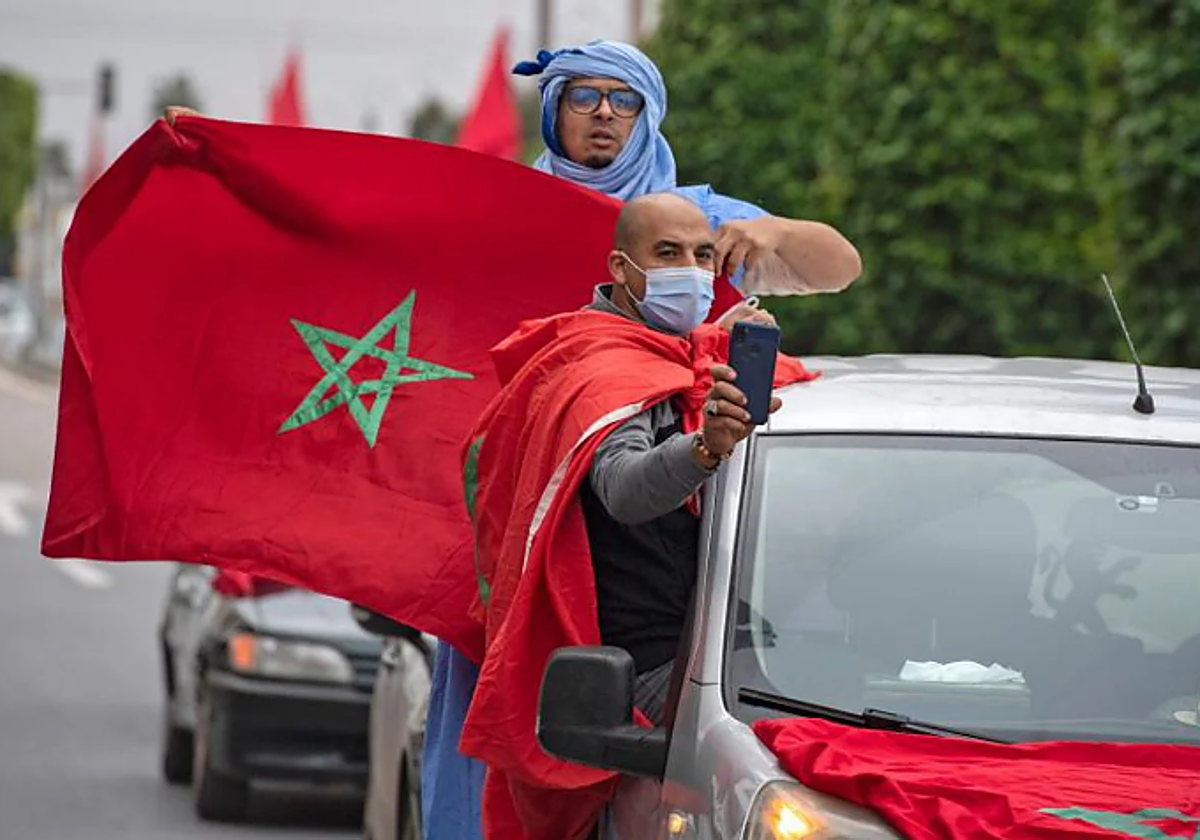 Los marroquíes celebran frente al edificio del parlamento en Rabat el 13 de diciembre de 2020, después de que Estados Unidos adoptara un nuevo mapa oficial de Marruecos que incluye el territorio disputado del Sáhara Occidental