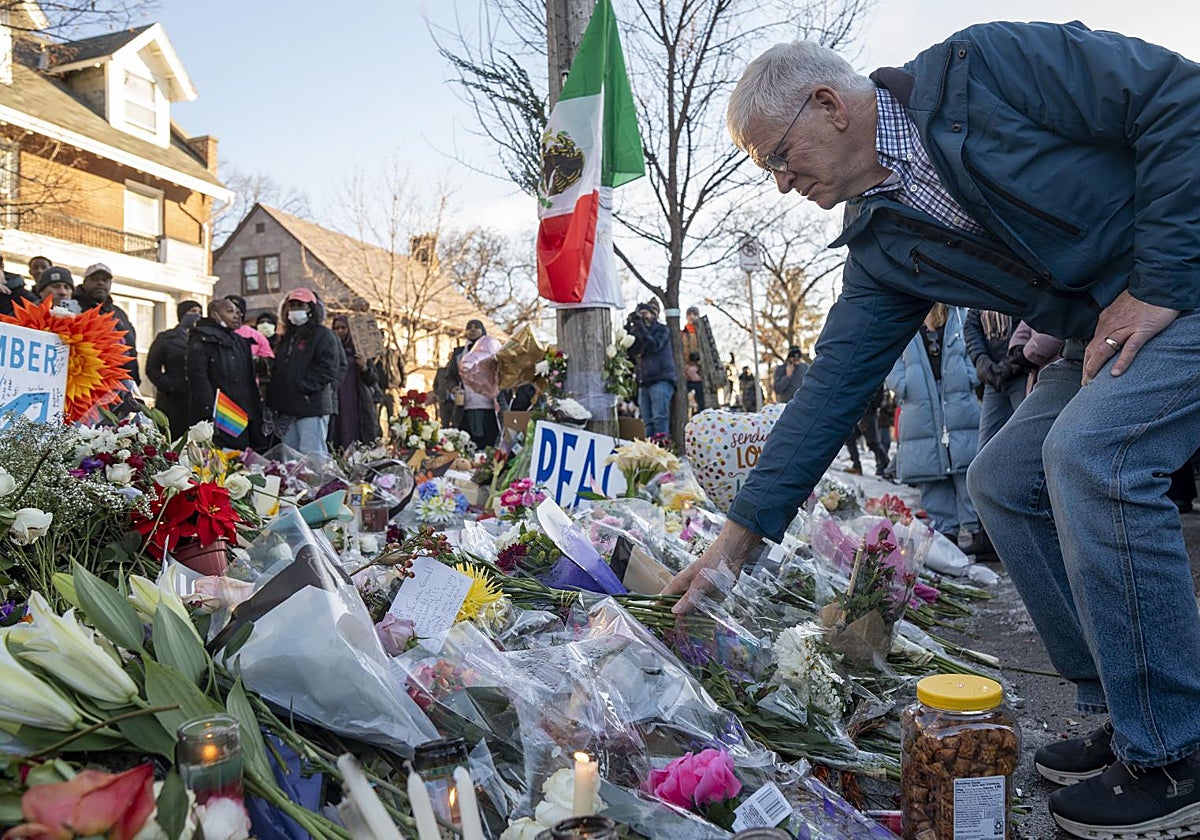 Un hombre deja flores en memoia de Renee Good, atropellada en Mineápolis