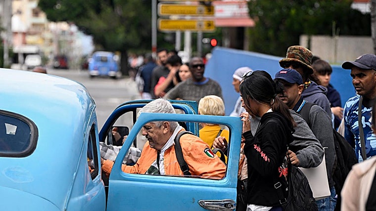 Várias pessoas viajam em táxi compartilhado em Havana