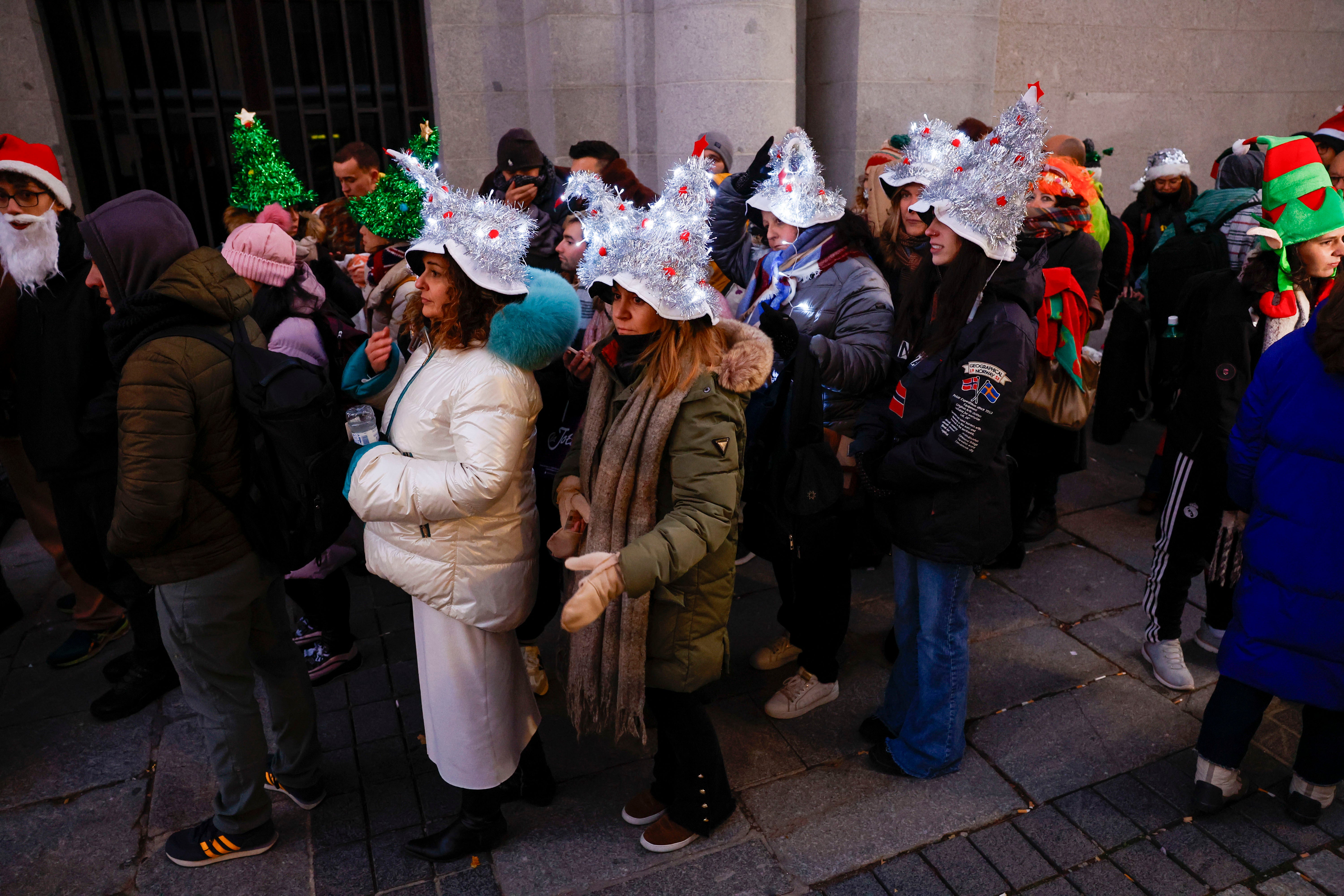 Asistentes al Teatro Real hacen cola el día de la Lotería de Navidad 2023.