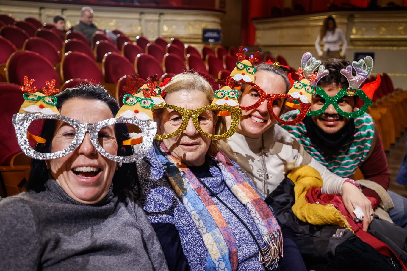 Varias señoras son fotografiadas antes de que comience el sorteo de la Lotería de Navidad. 