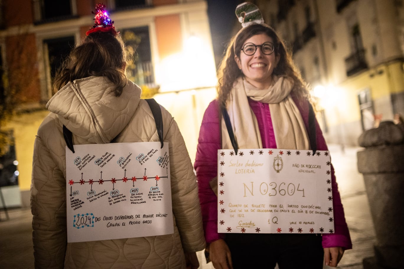 Dos mujeres acuden a las puertas del Teatro Real disfrazadas de décimos.