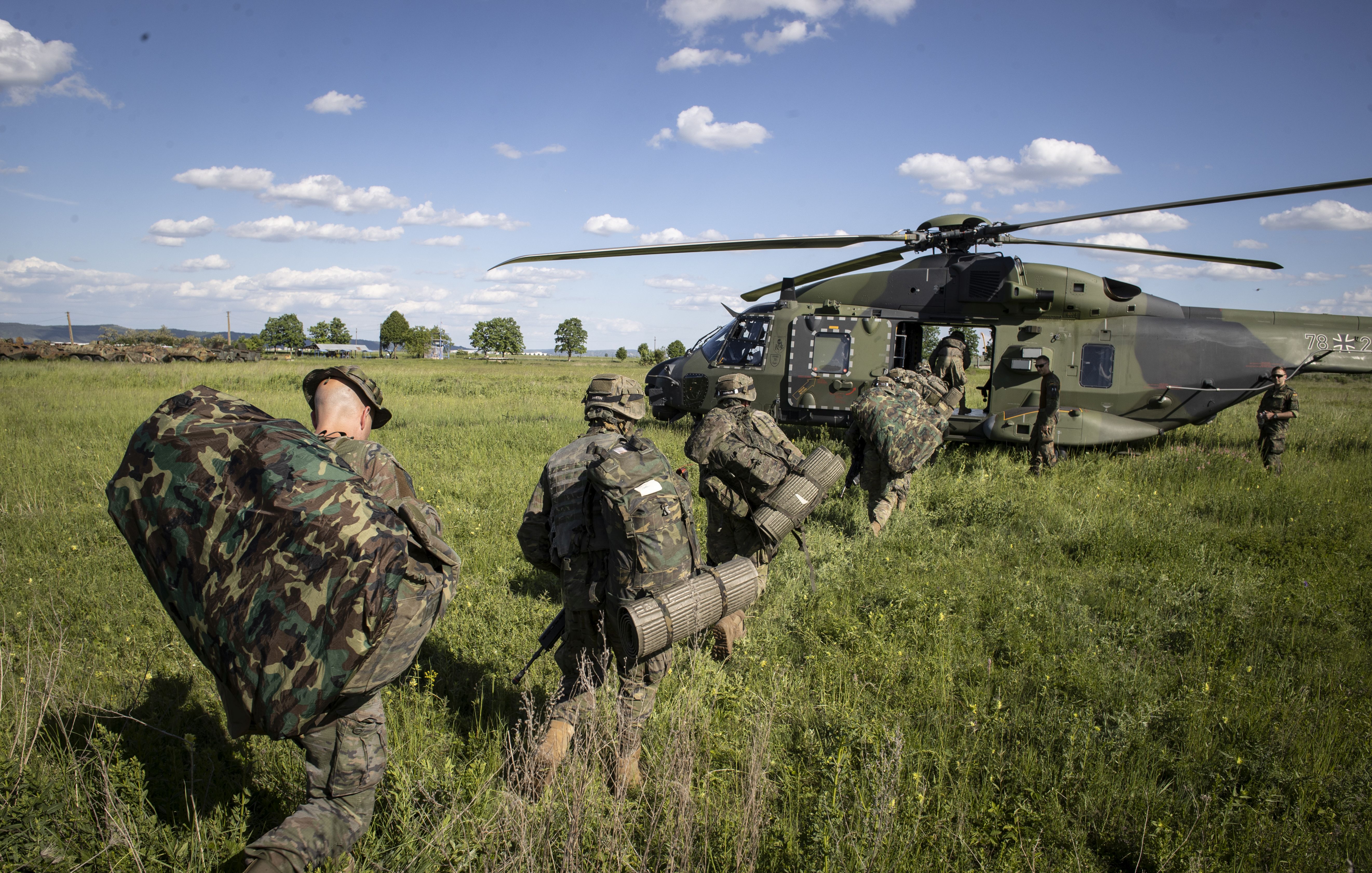 Los soldados se entrenan para la interoperabilidad entre ejércitos. Aquí, paracaidistas españoles se suben a un helicóptero alemán