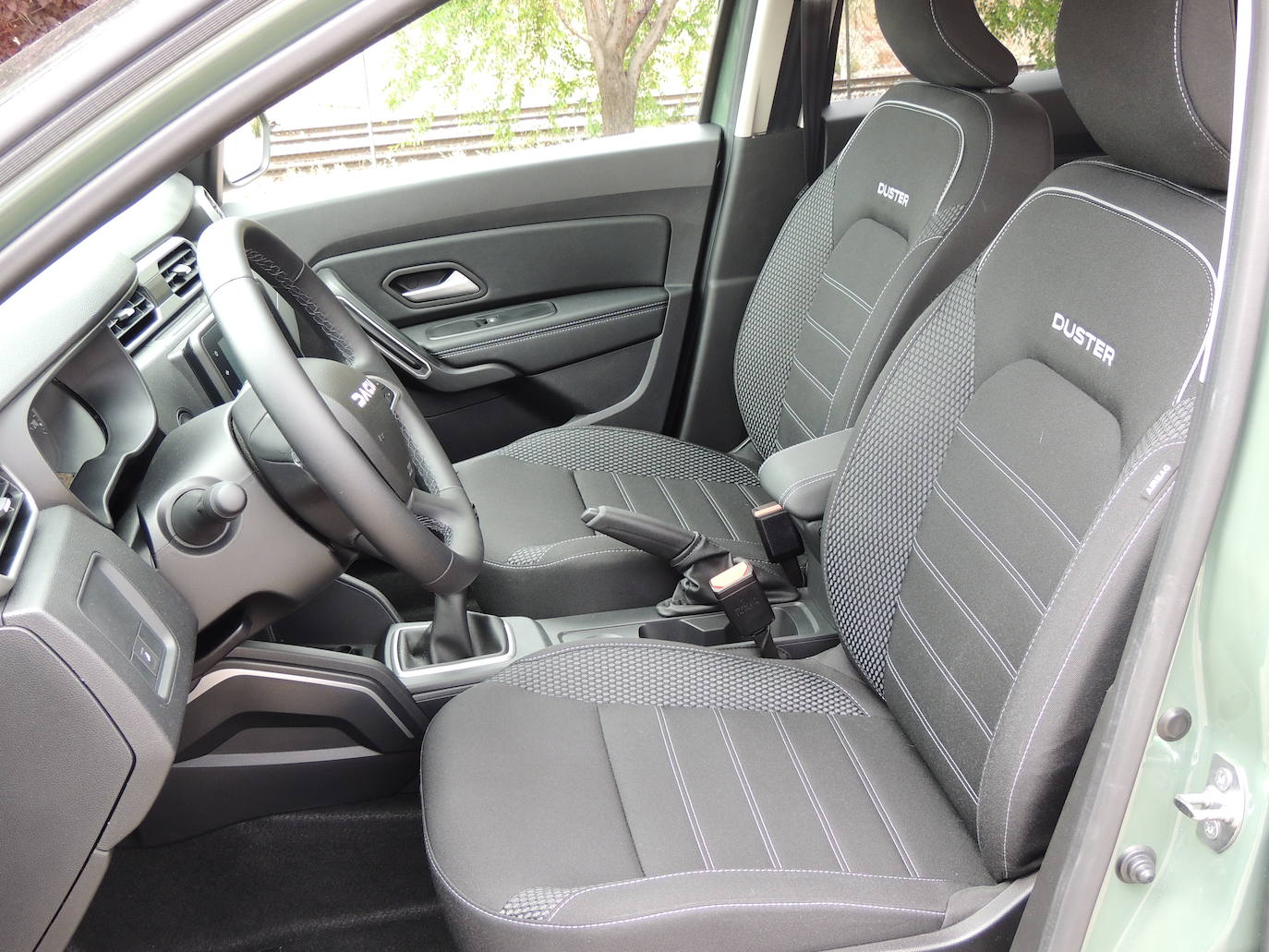 Pespuntes Marrón Cobre en el fuelle de la caja de velocidades, del freno de mano y en el reposabrazos central. Pespuntes Marrón Cobre en el fuelle de la caja de velocidades, del freno de mano y en el reposabrazos central. Reposabrazos de las puertas en tejido gris MicroCloud con pespuntes Marrón Cobre.