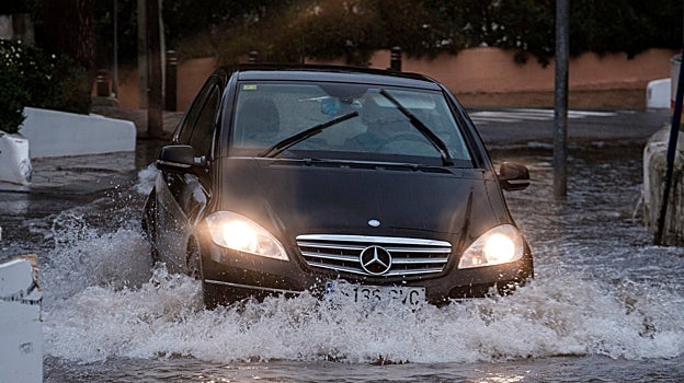 Un coche transita una calle inundada