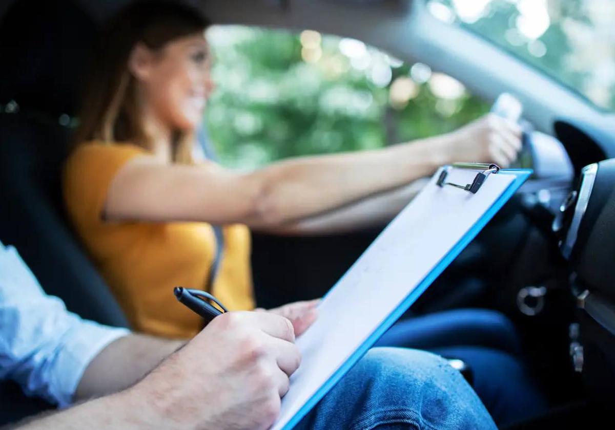 Una mujer examinándose del examen práctico para conseguir el carnet de conducir