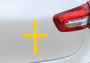 ¿Qué significa el símbolo de una cruz amarilla que muchos coches llevan en una pegatina?