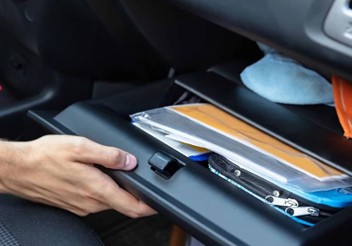 Imagen de archivo de un conductor abriendo la guantera del coche