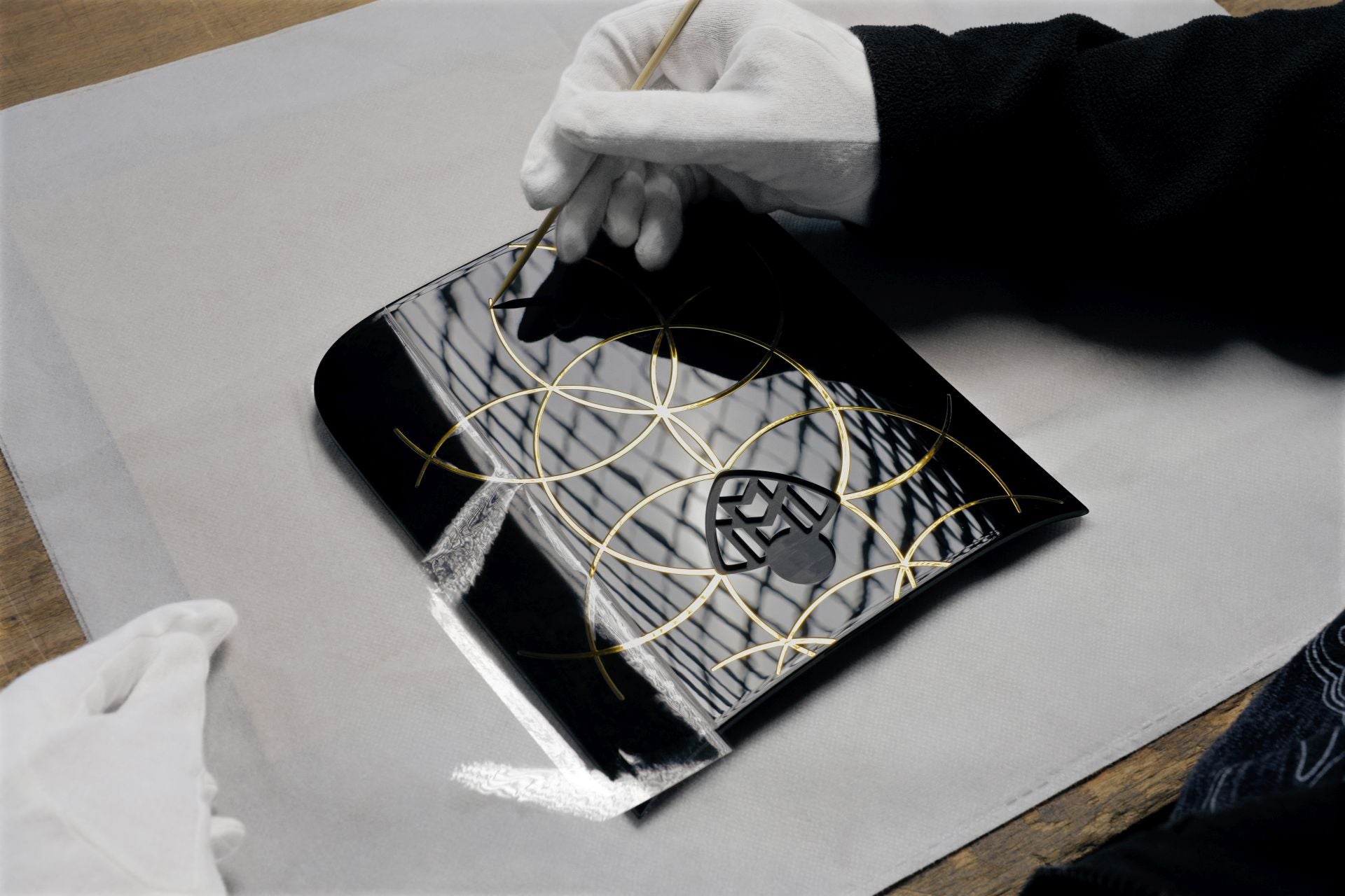 Una incrustación dorada adorna la consola central trasera. El emblema de Maybach, completo con su medalla conmemorativa y su «12», está enmarcado por doce círculos dorados, un sutil guiño al icónico patrón de la marca Maybach.