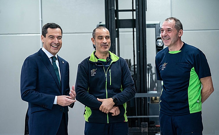 Imagen principal - El presidente de la Junta eligió una cooperativa de aceite para lanzar su mensaje de Fin de Año y brindar con los trabajadores de la misma