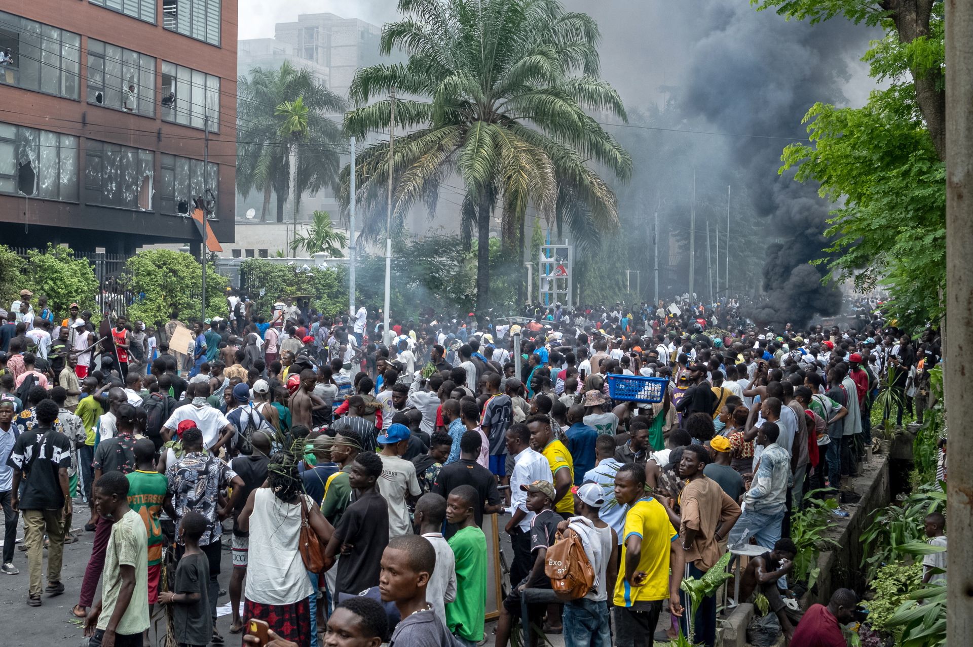 Imagen principal - Protestas en Kinshasa. Mercenarios rumanos hacen cola para ser examinados mientras son evacuados de Goma y un vehículo de la misión de la ONU MONUSCO en los enfrentamientos
