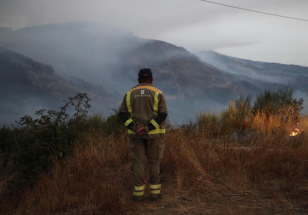 Un bombero forestal observa el paisaje del incendio de A Pobra de Brollón desde Quiroga (Lugo).