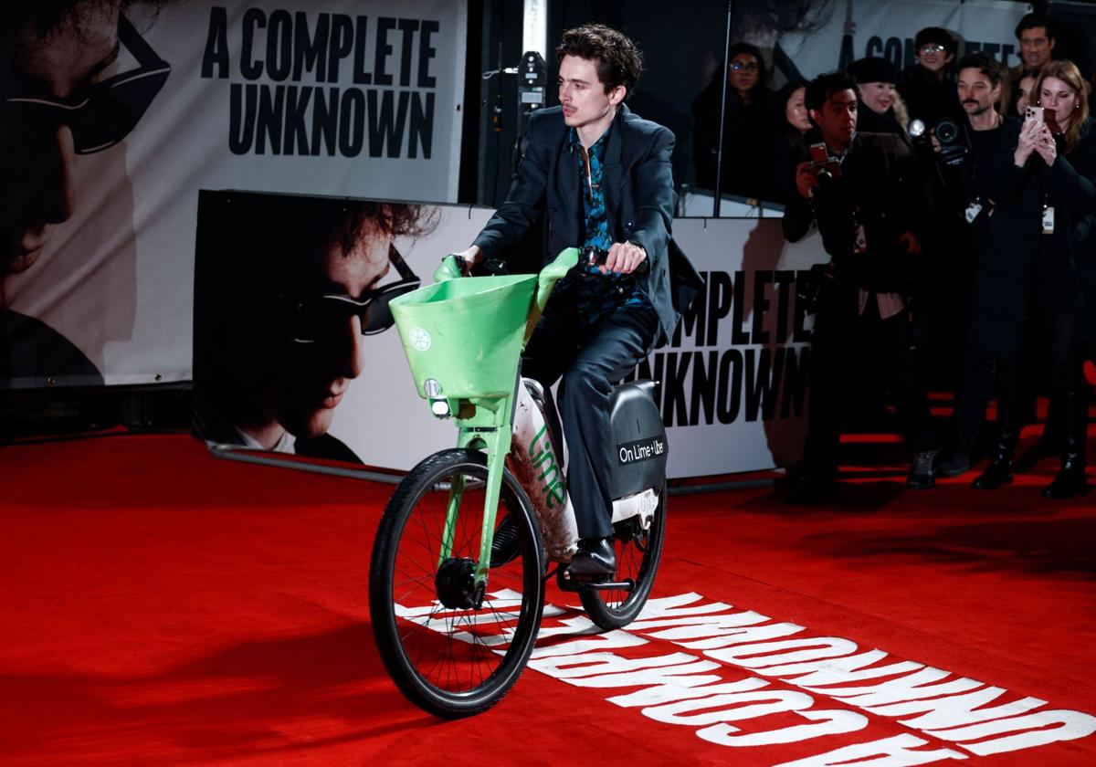 Timothée Chalamet llegando al estreno de 'Un completo desconocido' en bicicleta