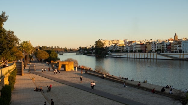 Gente descansando y paseando junto al río Guadalquivir