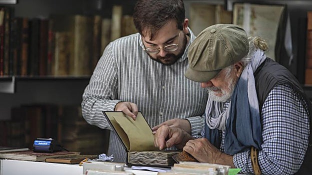 Dos personas ojeando una primera edición