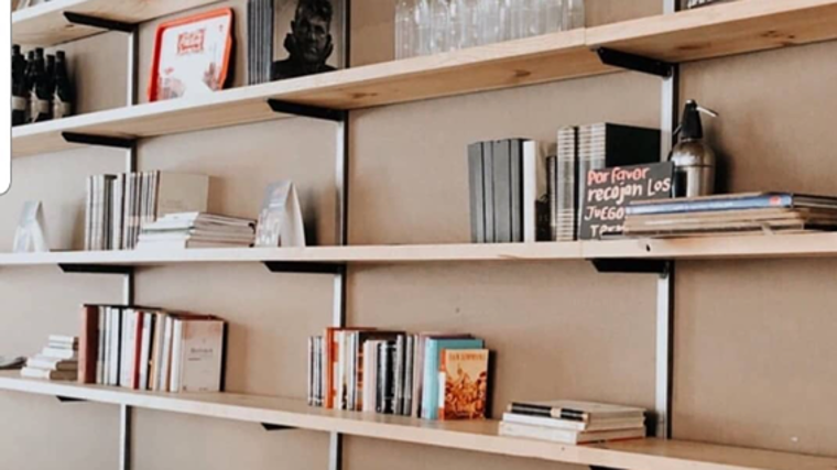 Estantería del interior de Orfeo Café Cultural, con libros y juegos de mesa