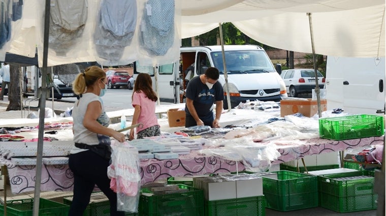 Varias personas en un puesto de zapatos del mercadillo de Tomares