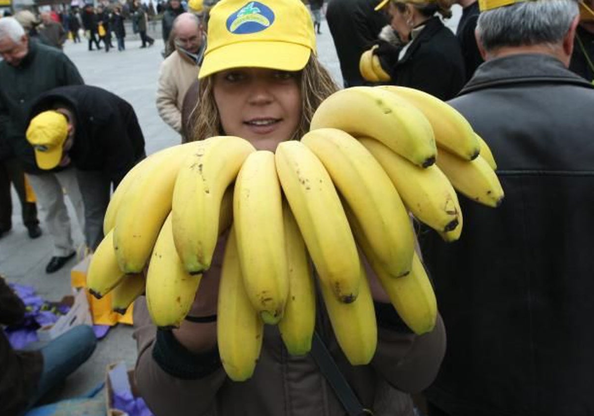 Una joven, mostrando plátanos durante una campaña de plátano de Canarias