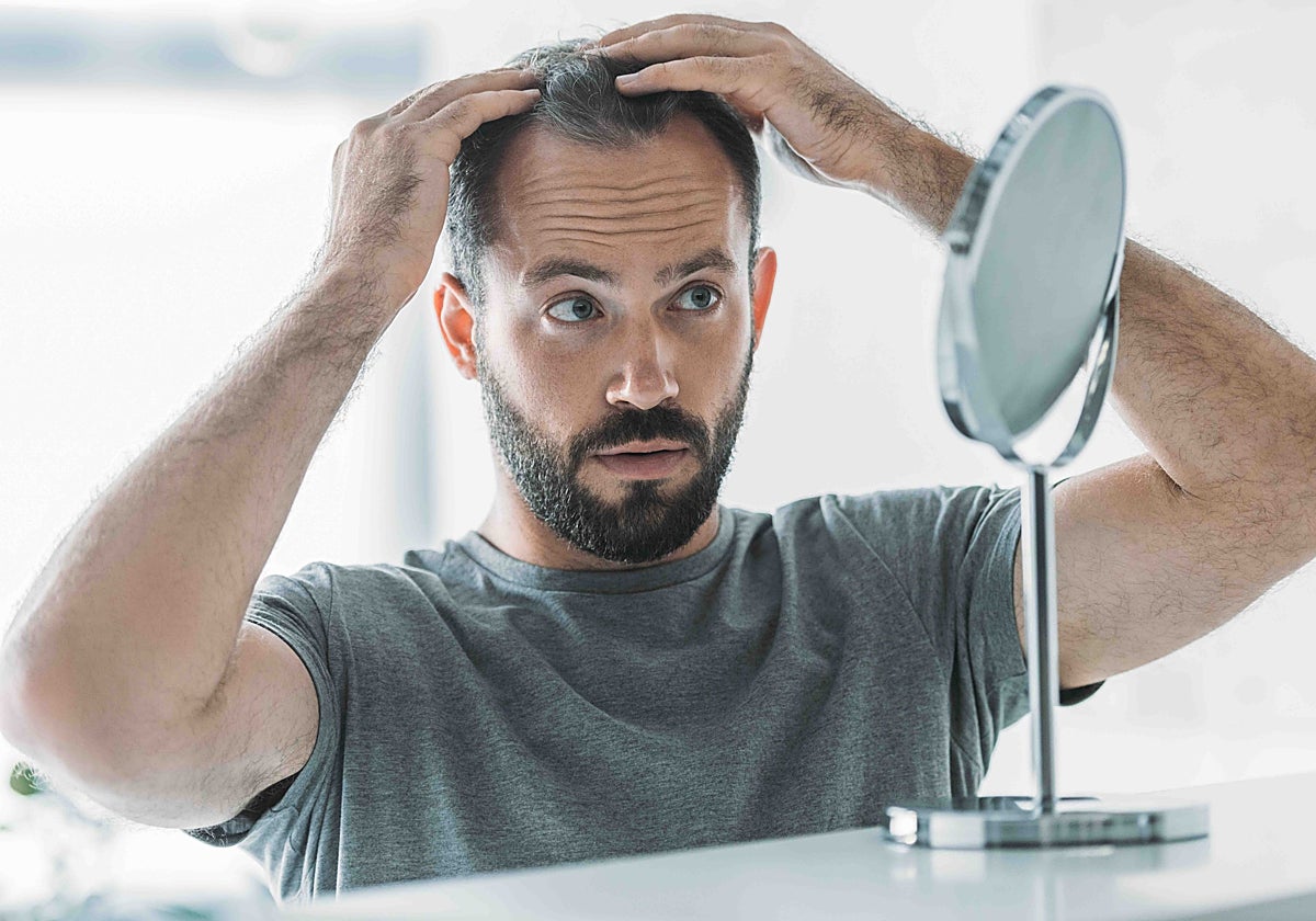 Un hombre se aplica un producto anticaida