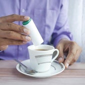 Una persona endulza su bebida
