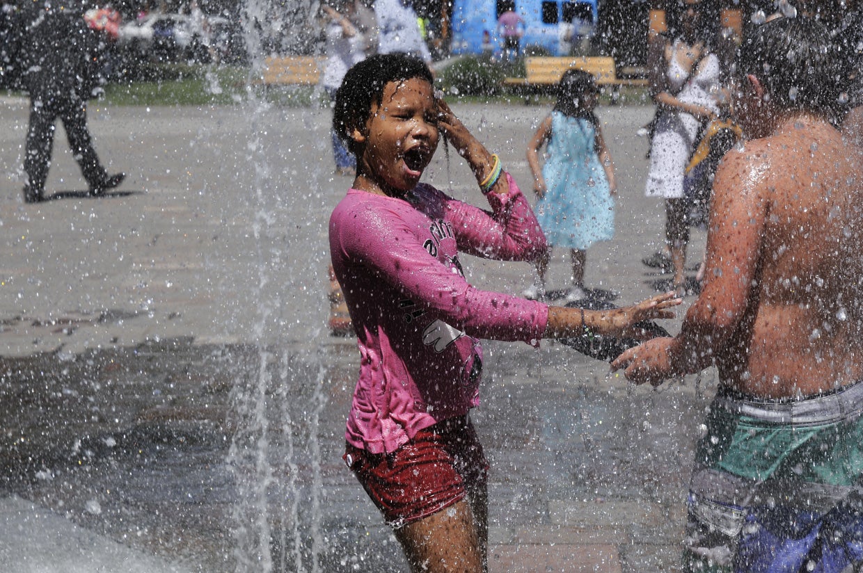 Una niña se refresca durante una ola de calor