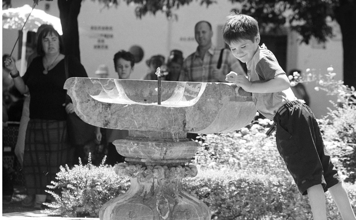Un niño en la fuente de la plaza de Doña Elvira
