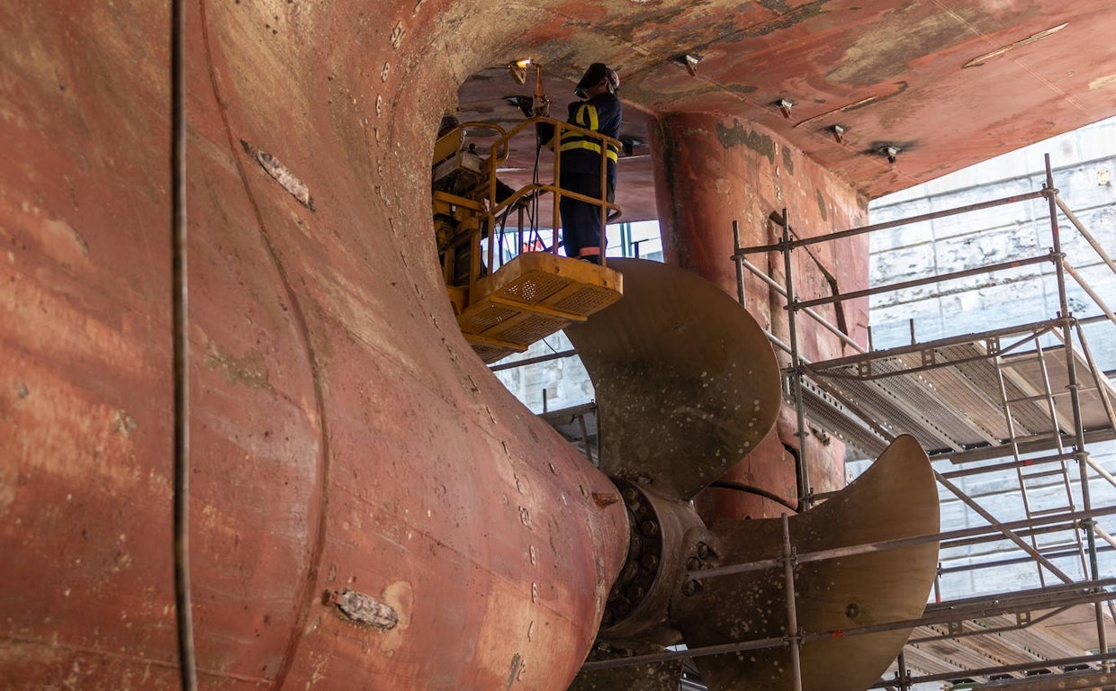 Un trabajadores del Astillero revisa el casco de «Greta», un carguero de bandera finlandesa, en el dique seco del Astillero sevillano