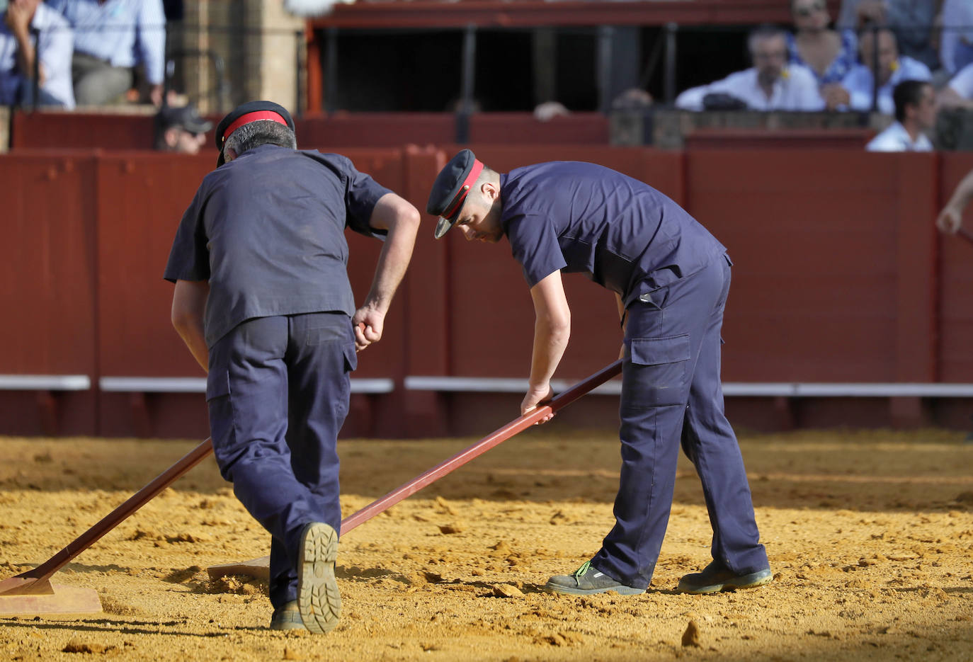 Dos monosabios o mozos de ayuda, limpian el albero de la plaza