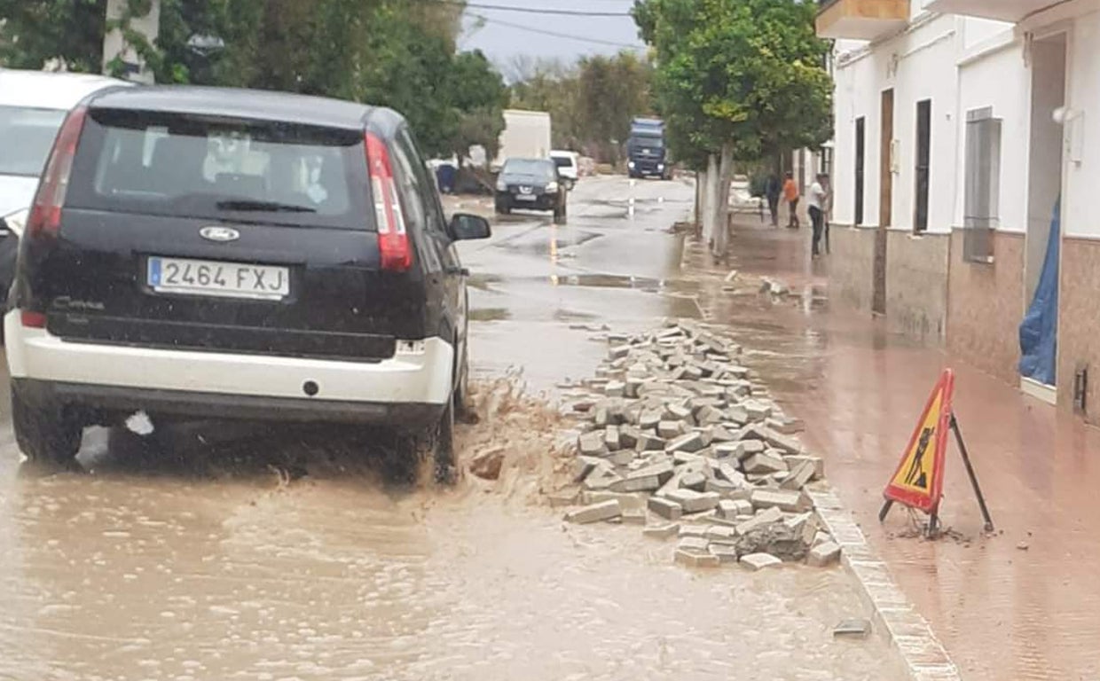 Un coche circula por una de las calles de Marinaleda / Tormenta sorpresa en el sur de la provincia