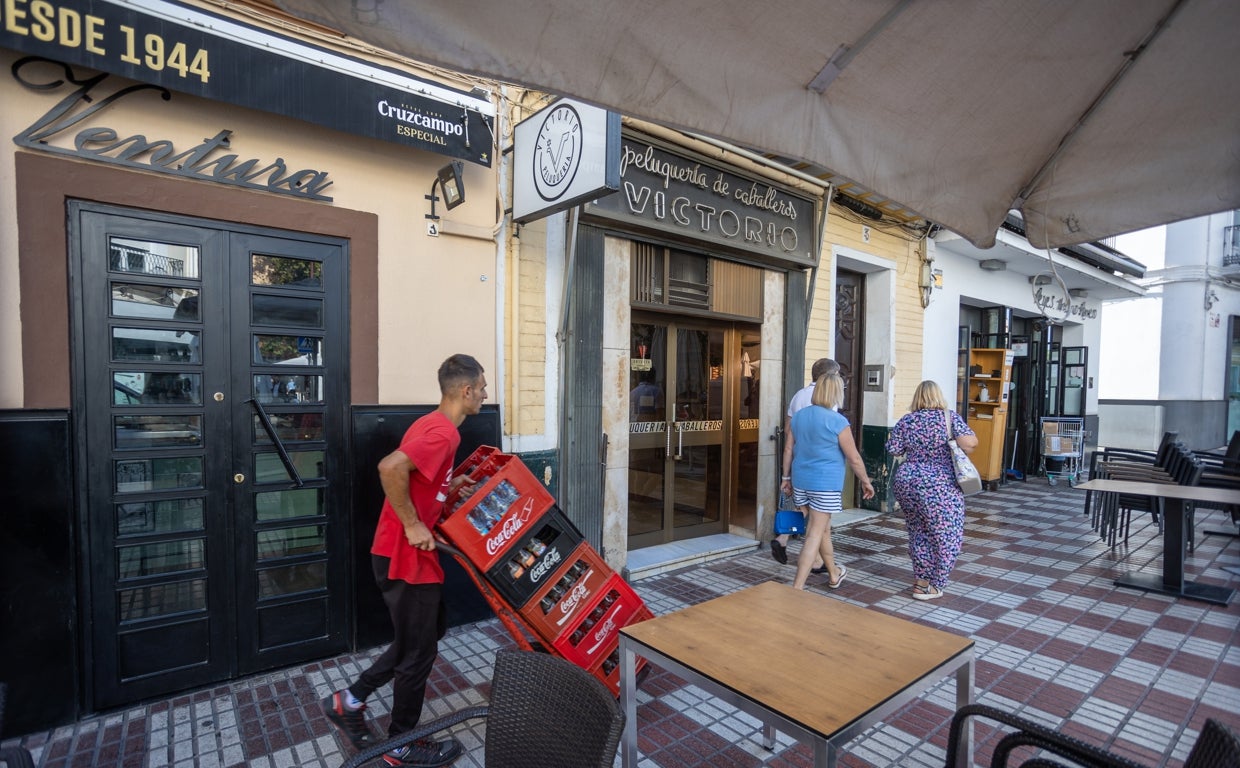 El paseo de los turistas contrasta con el trabajador y su carretilla