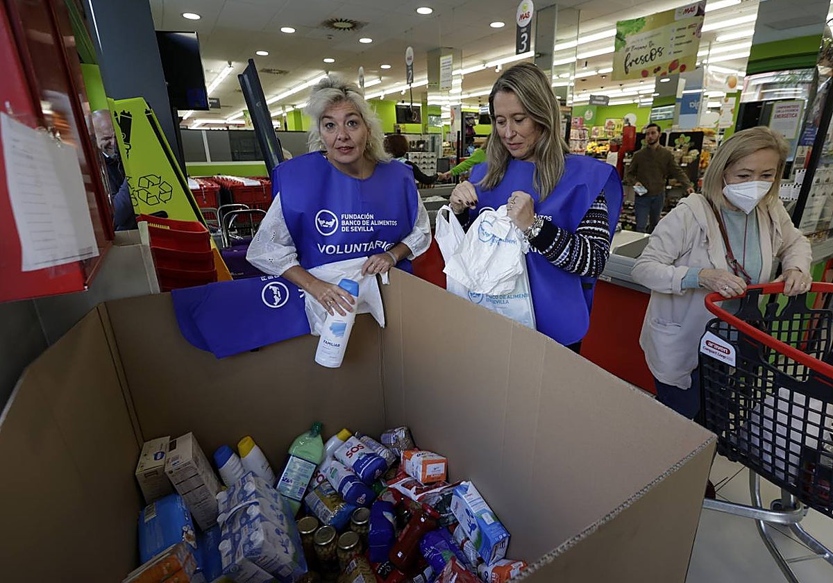 Dos voluntarias recogen alimentos en un supermercado de Sevilla
