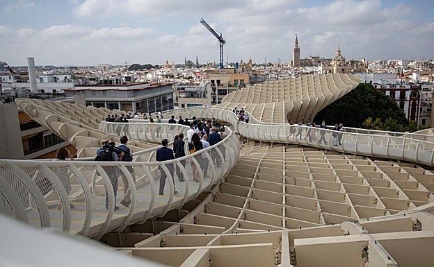 Varias personas pasean por el mirador de las Setas de Sevilla, con la Giralda en el fondo