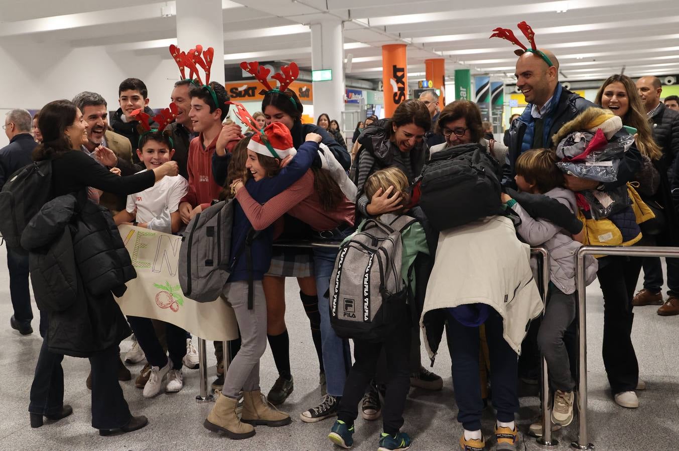 La zona de llegadas del aeropuerto sevillano se llena estos días de unos besos y abrazos muy esperados 