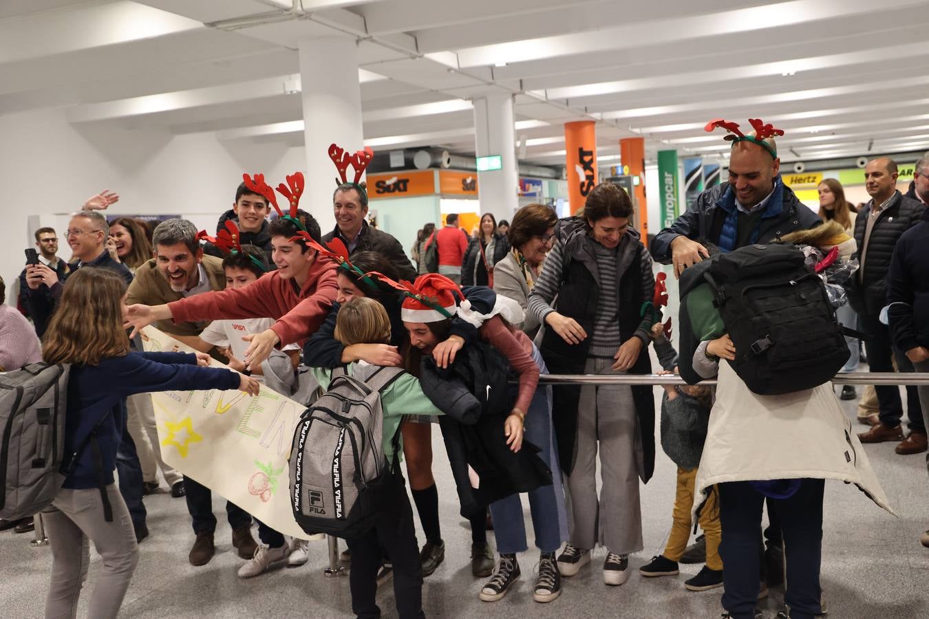 La zona de llegadas del aeropuerto sevillano se llena estos días de unos besos y abrazos muy esperados 