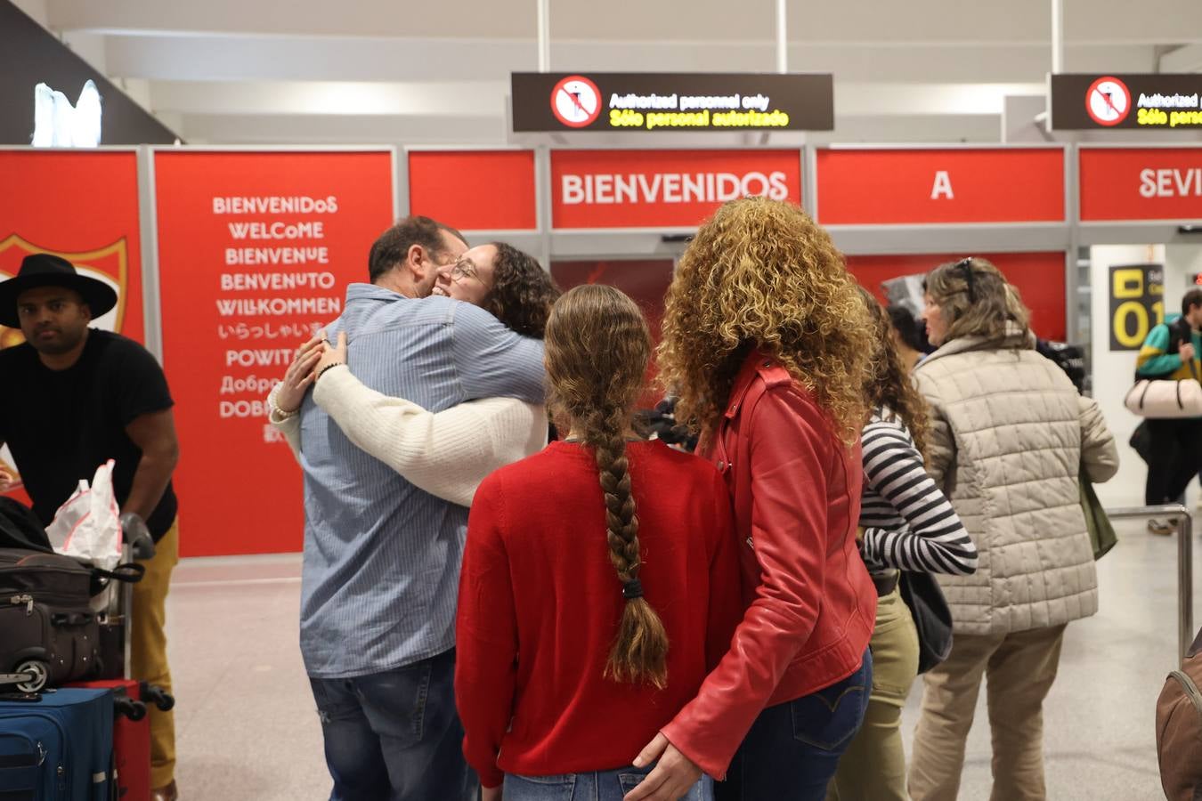 La zona de llegadas del aeropuerto sevillano se llena estos días de unos besos y abrazos muy esperados 