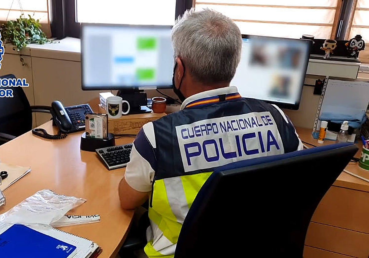 Un agente de la Policía Nacional revisa el material incautado en una operación contra un pederasta