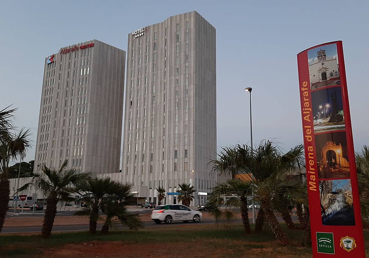 Un cartel de Mairena del Aljarafe ante las dos torres del municipio en Ciudad Expo