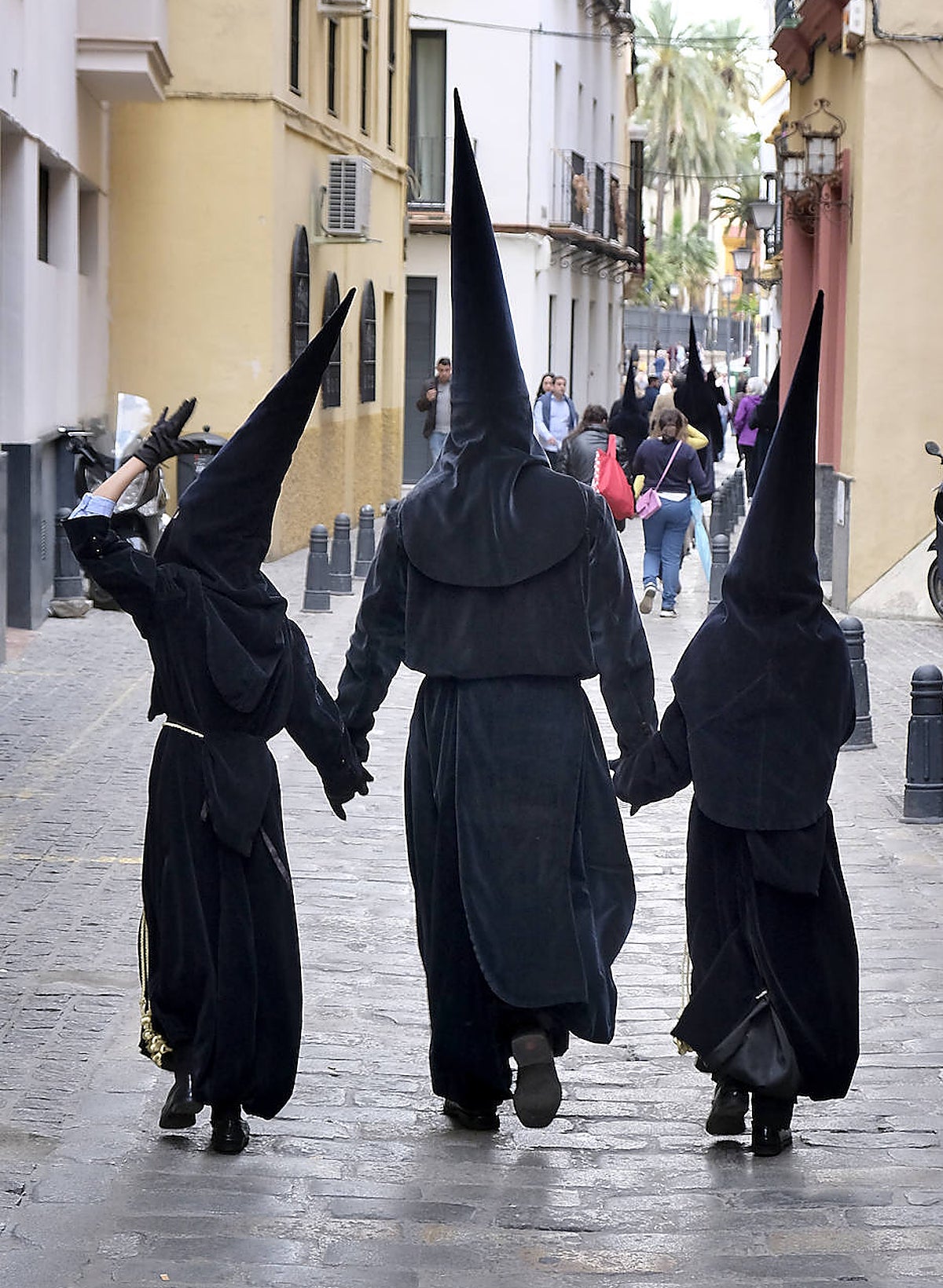 Tres nazarenos de la Carretería de vuelta a su casa tras suspenderse la salida