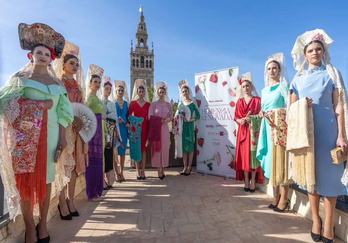 Unas jóvenes con mantilla blanca posan con la Giralda al fondo en la jornada de la Mantilla blanca