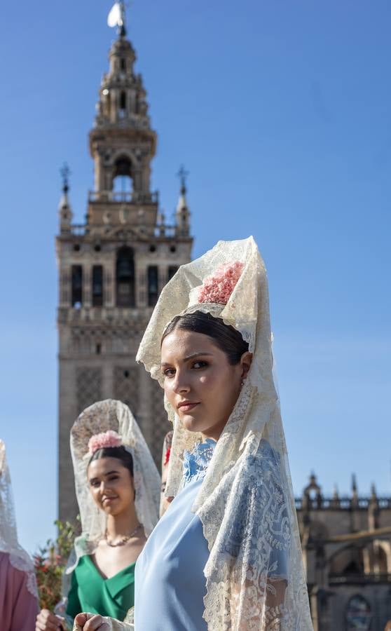 Unas jóvenes con mantilla blanca posan con la Giralda al fondo en la jornada de la Mantilla blanca