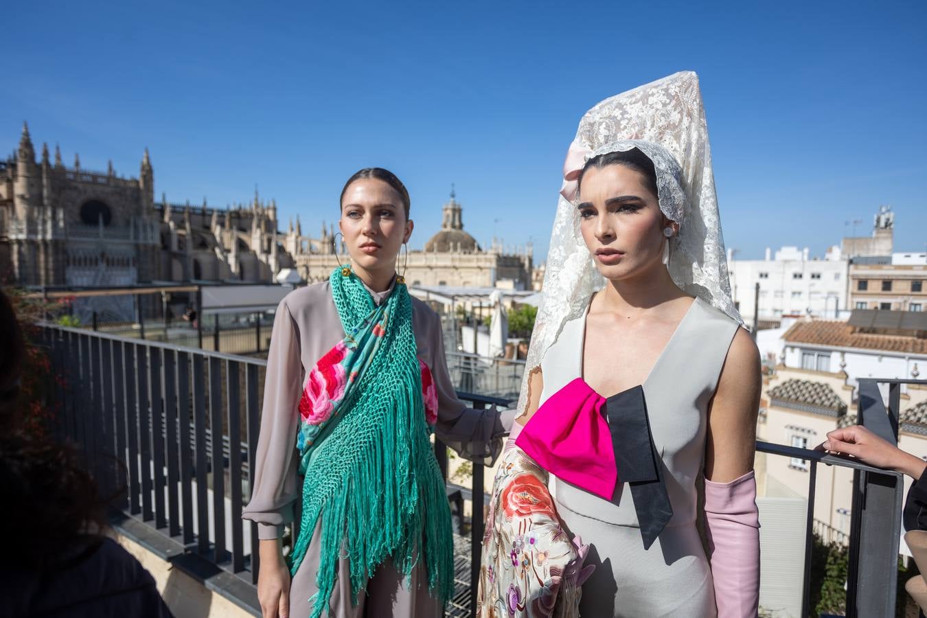 Unas jóvenes con mantilla blanca posan con la Giralda al fondo en la jornada de la Mantilla blanca