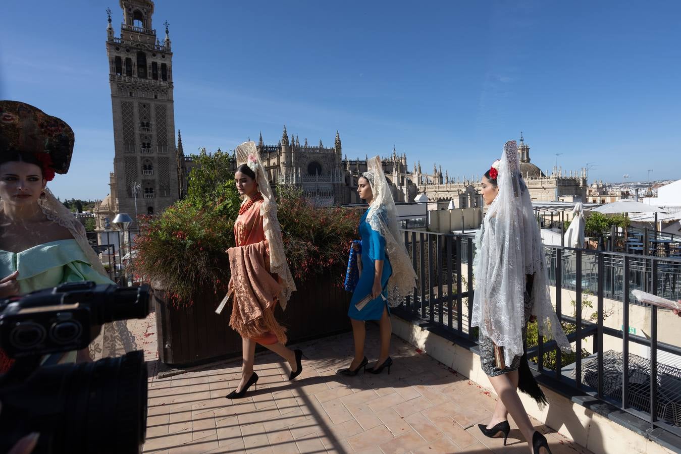 Unas jóvenes con mantilla blanca posan con la Giralda al fondo en la jornada de la Mantilla blanca