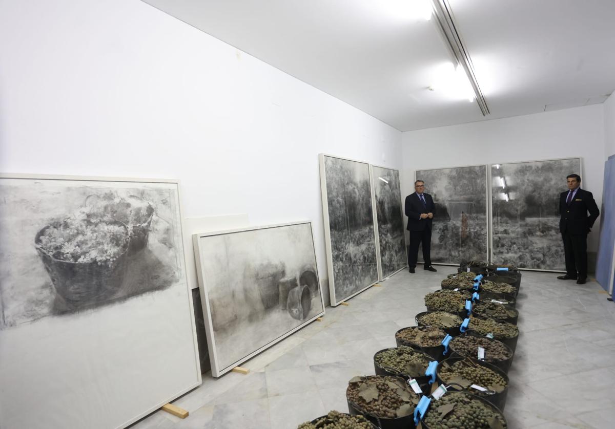 El consejero de Turismo, Cultura y Deporte, Arturo Bernal junto al sobrino de la pintora, Manuel Laffón y parte de las obras recepcionadas en los almacenes del Centro Andaluz de Arte Contemporáneo