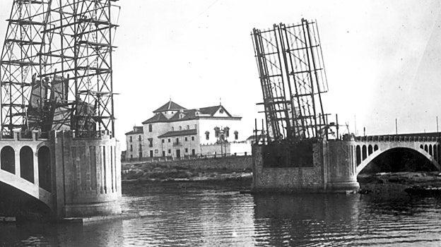 Puente de San Telmo en construcción con el esqueleto de la parte movible. Al fondo, el monasterio de Los Remedios