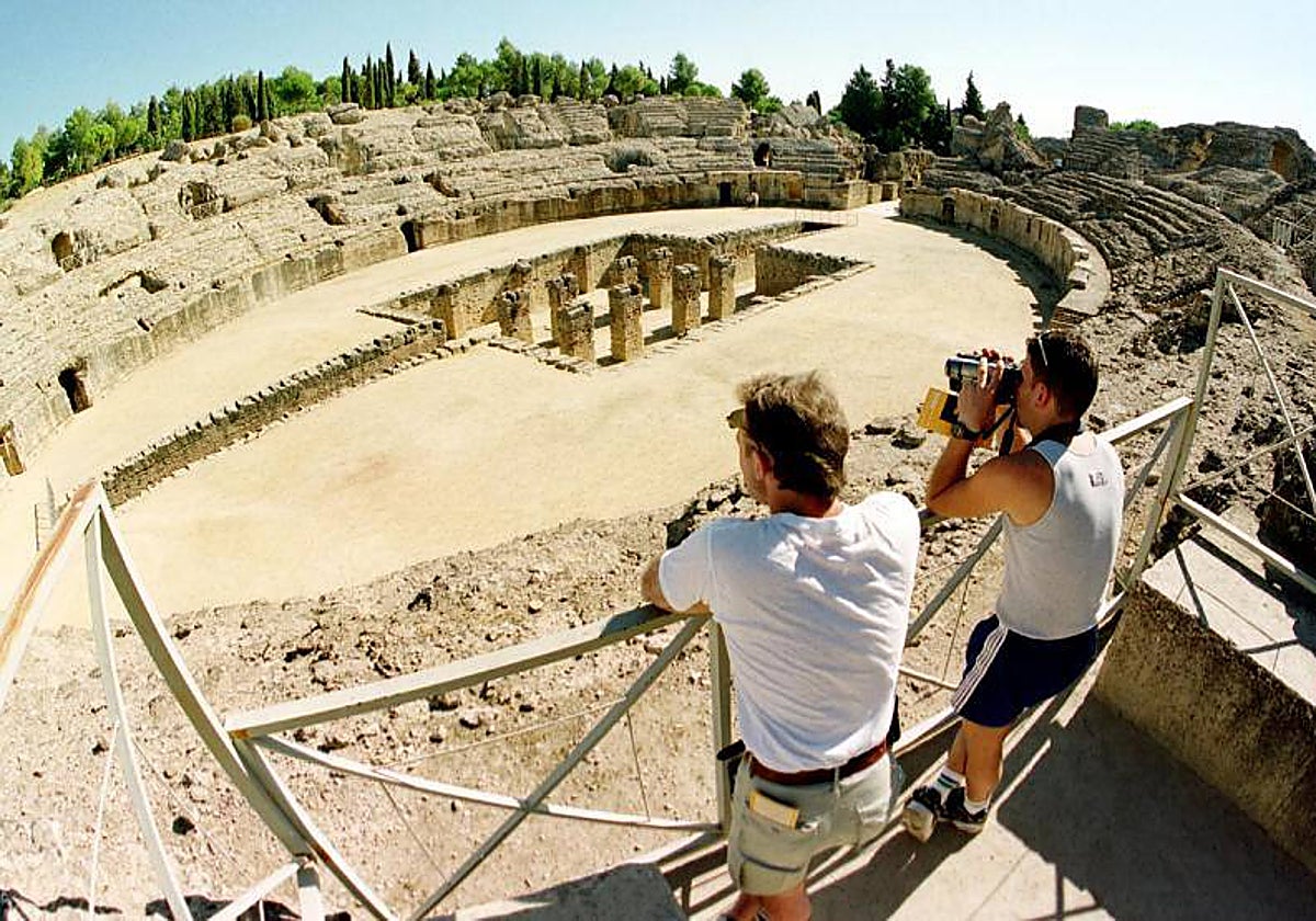 Dos turistas visitan el anfiteatro de las ruinas romanas de Itálica, en Santiponce