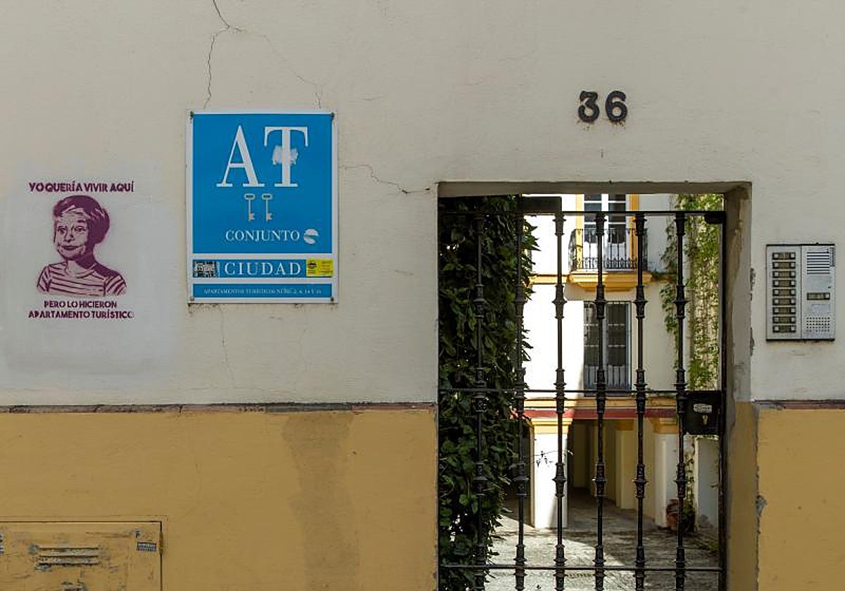 Entrada a unos apartamentos turísticos de Sevilla con una pintada en contra de este tipo de alojamientos