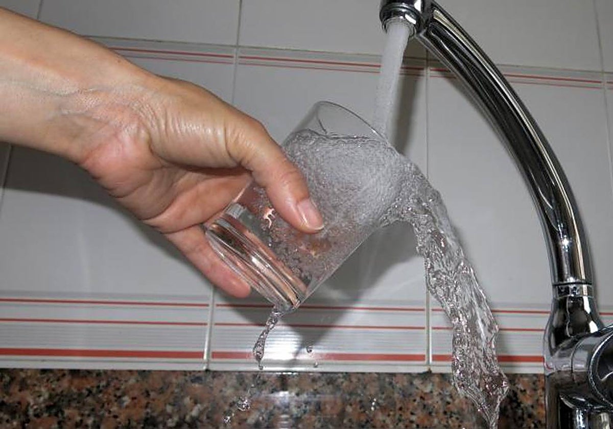 Una persona llena un vaso de agua del grifo